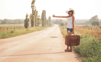 Young woman with a suitcase on a road | Source: Shutterstock