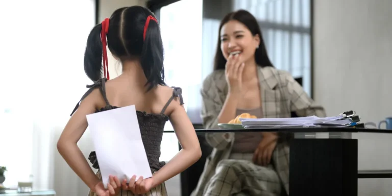 A girl holding a card behind her back | Source: Shutterstock