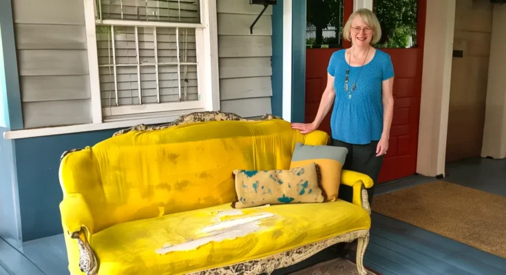 A woman standing next to an old, stained couch | Source: AmoMama