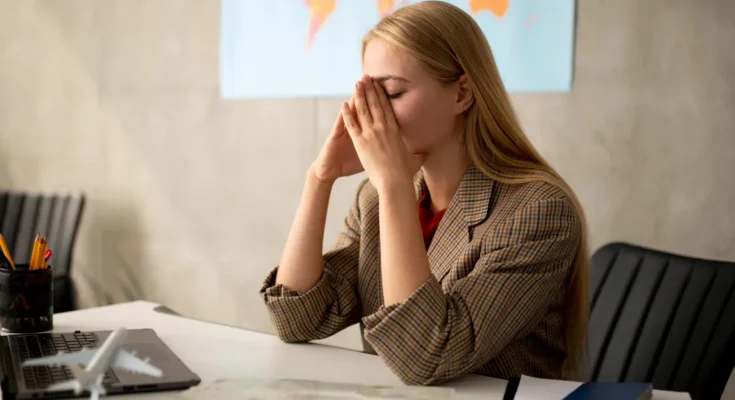 A frustrated woman sits at a desk | Source: Freepik