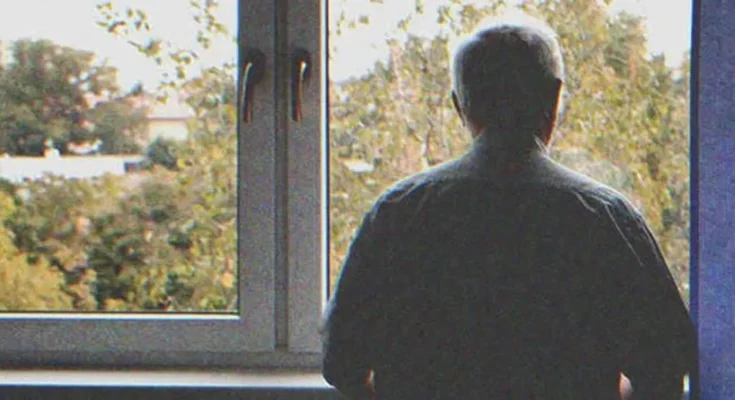 Old man looking out a window | Source: Shutterstock