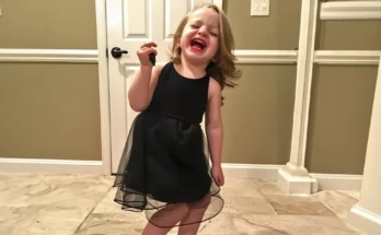 A little girl wearing a black dress and red lipstick | Source: Amomama