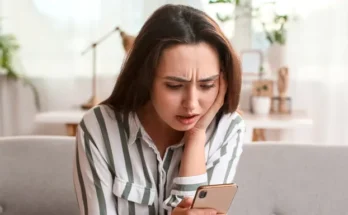 A shocked woman reading a text on her phone | Source: Shutterstock