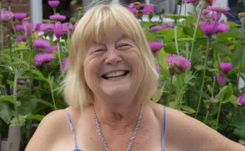 A happy woman smiling while surrounded by flowers | Source: Amomama