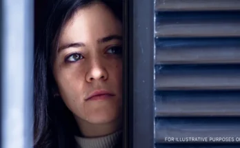 A woman watching through a door/window and crying | Source: Shutterstock