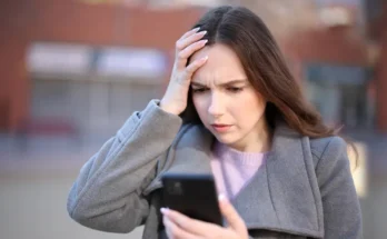 A shocked woman looking at her phone | Source: Shutterstock