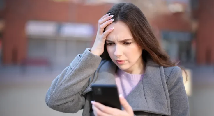 A shocked woman looking at her phone | Source: Shutterstock