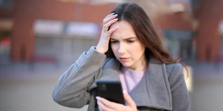 A shocked woman looking at her phone | Source: Shutterstock