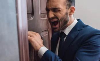 An angry man knocking on a door | Source: Shutterstock