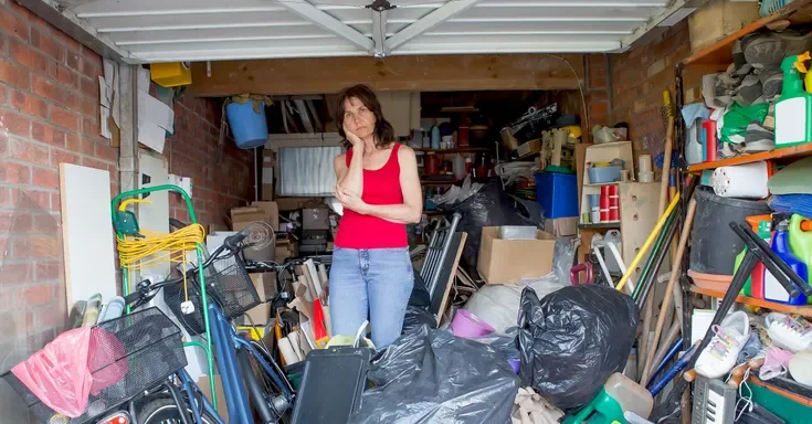 A woman standing in a garage filled with various items | Source: Shutterstock