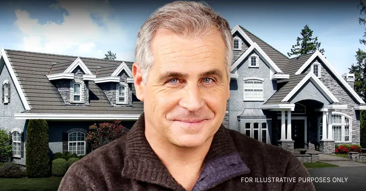 A middle-aged man smiling against the backdrop of a mansion | Source: Shutterstock