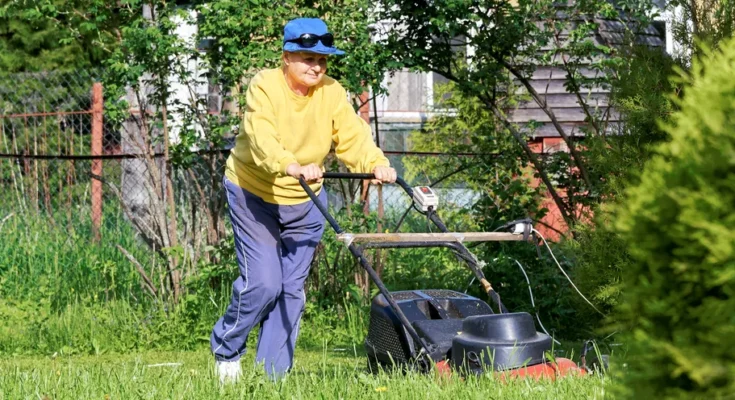 A woman mowing her lawn | Source: Shutterstock