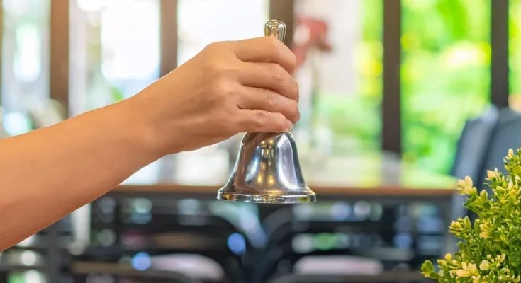 Woman ringing a restaurant service bell | Source: Shutterstock