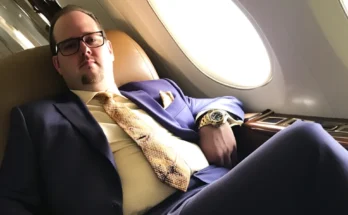 A man in a suit sitting in an airplane | Source: AmoMama