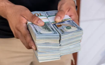 A man holding a stack of money | Source: Shutterstock