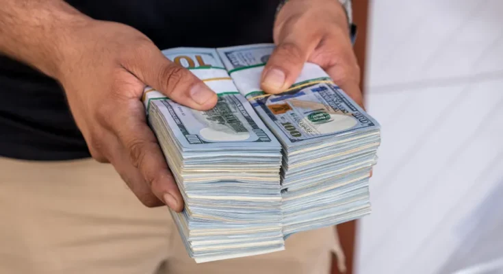 A man holding a stack of money | Source: Shutterstock