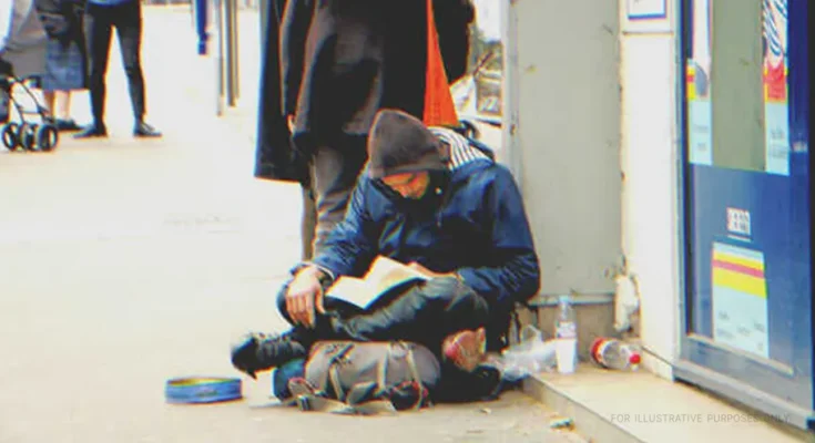 A homeless man reading a book | Source: Shutterstock