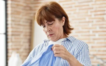 A senior woman holding a blue dress | Source: Shutterstock