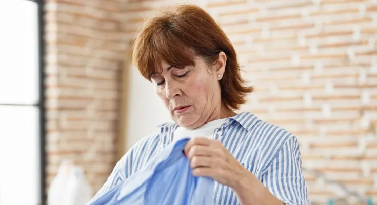 A senior woman holding a blue dress | Source: Shutterstock