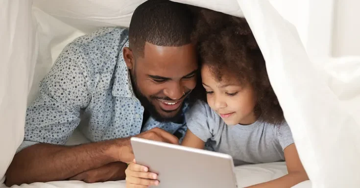 A father and daughter duo using a Tablet | Source: Shutterstock