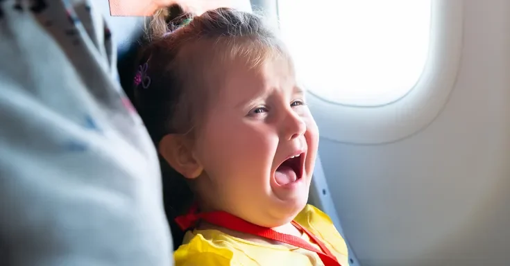 A little girl crying in an airplane | Source: Shutterstock