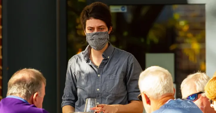 Waitress using a facemask. | Source: Getty Images