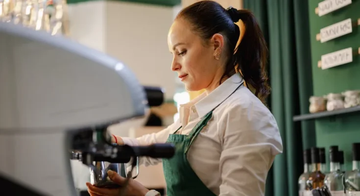 A female barista making coffee | Source: Shutterstock