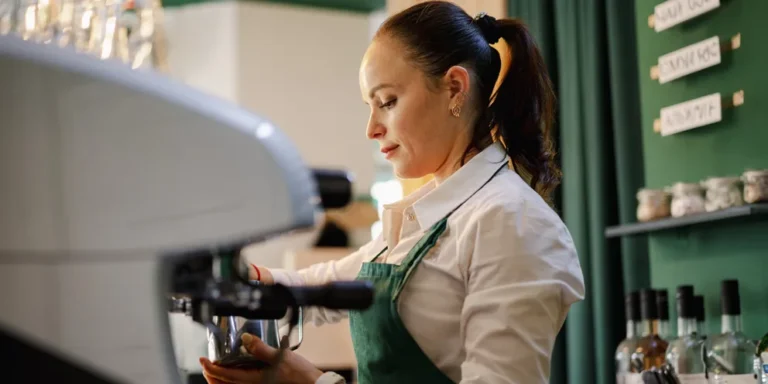 A female barista making coffee | Source: Shutterstock