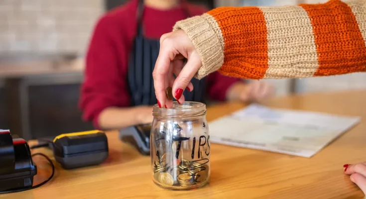 A female customer leaving tips at the tip jar | Source: Getty Images