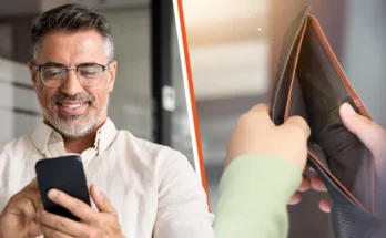 A man looking at his phone and an empty wallet | Source: Shutterstock