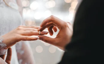 A man placing a wedding band on a women's finger| Source: Amomama