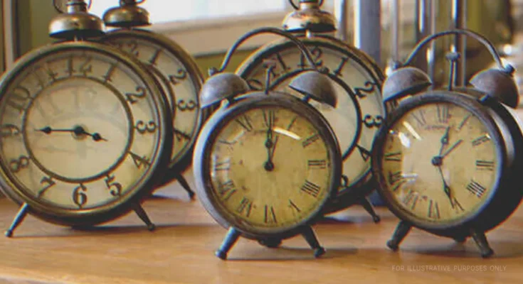 Five vintage alarm clocks on a table | Shutterstock