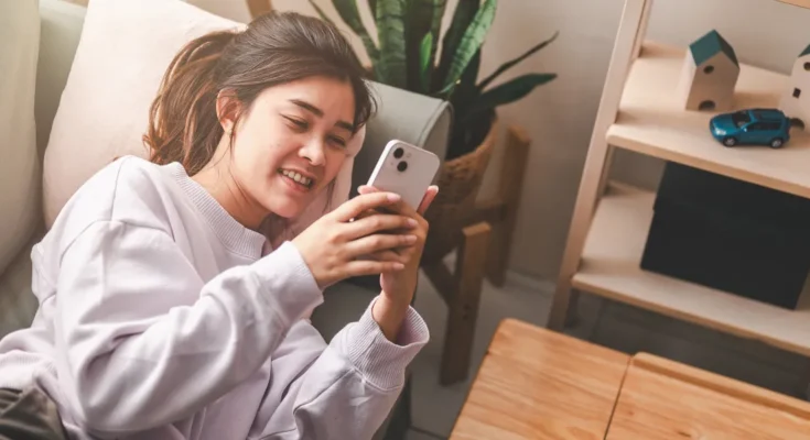 A woman using her phone | Source: Shutterstock