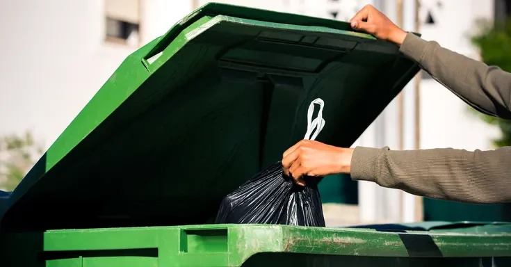 A person throwing trash into a bin | Source: Shutterstock