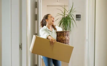 A woman carrying a box and plant | Source: Shutterstock