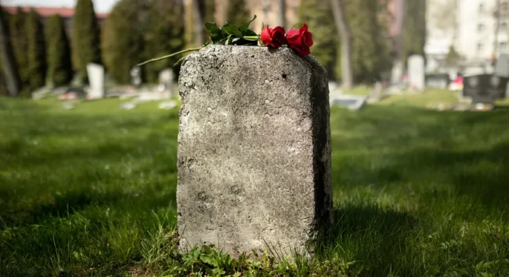 A gravestone with a flower | Source: Freepik