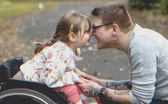 Man leaning nose to nose with disabled girl. | Source: Getty Images