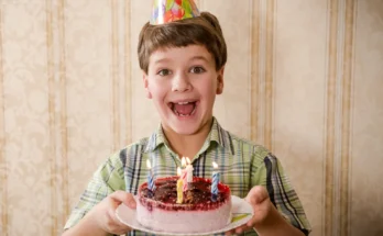 A boy holding a birthday cake | Source: Shutterstock