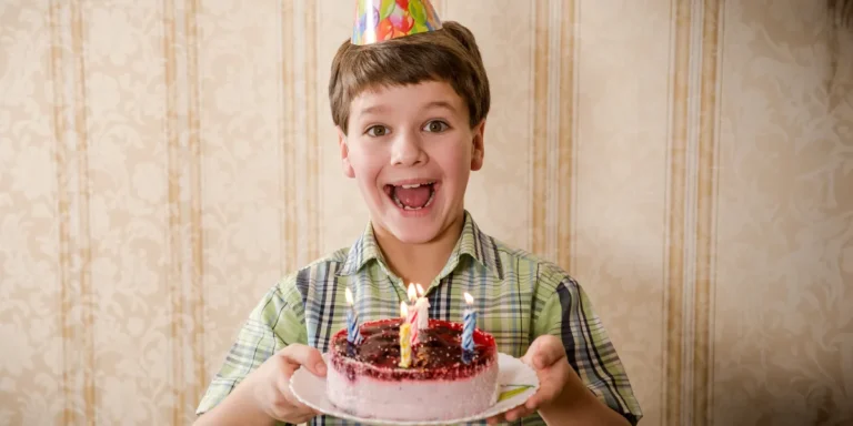 A boy holding a birthday cake | Source: Shutterstock