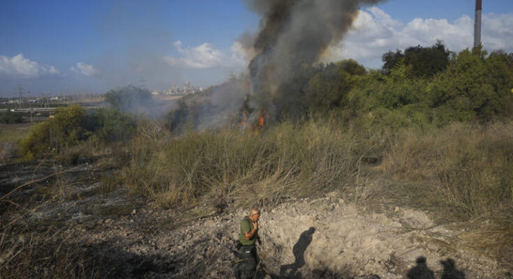 A police officer inspects the area around a fire after the military said it fired interceptors at a missile launched from Yemen that landed in central Israel on Sunday, Sept. 15, 2024. (AP Photo/Ohad Zwigenberg)