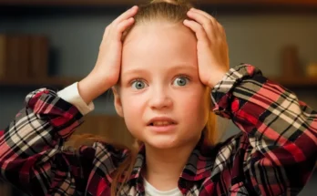 A little girl holding her head | Source: Shutterstock