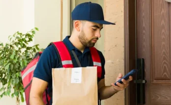 A delivery man with a phone | Source: Shutterstock