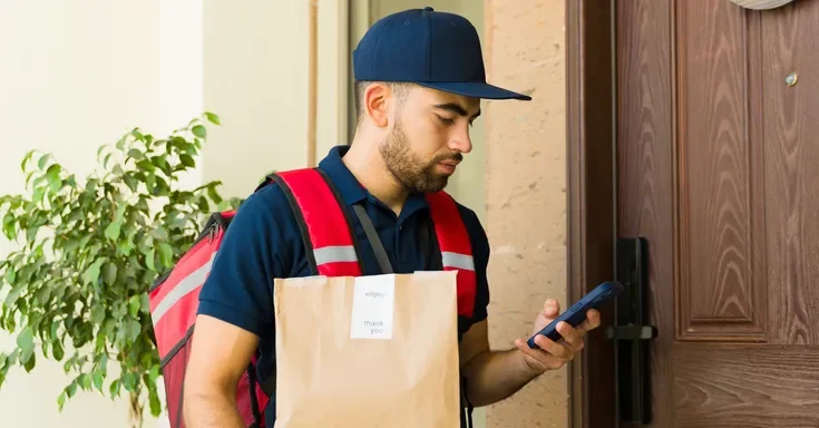 A delivery man with a phone | Source: Shutterstock