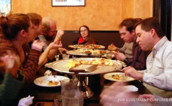 People sitting around a table and eating | Source: Flickr