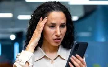 A woman looking at her phone | Source: Shutterstock