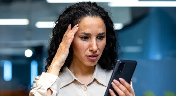 A woman looking at her phone | Source: Shutterstock