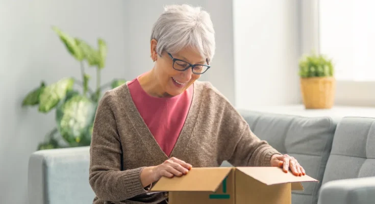 An old woman opening a box | Source: Shutterstock