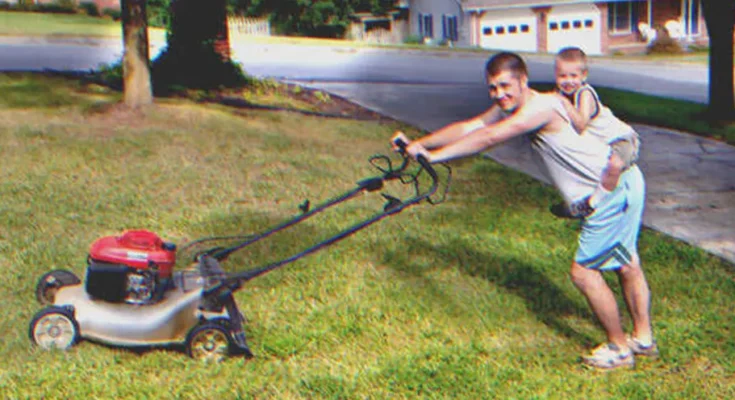 Man mowing lawn with a young boy on his back | Source: Shutterstock