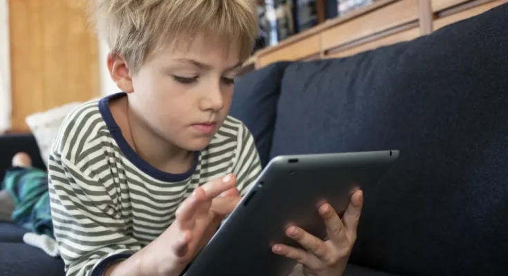 Boy engrossed in a tablet | Source: Shutterstock