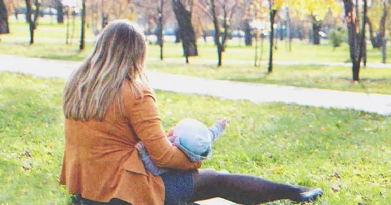 Woman with a baby sitting in the grass | Source: Shutterstock